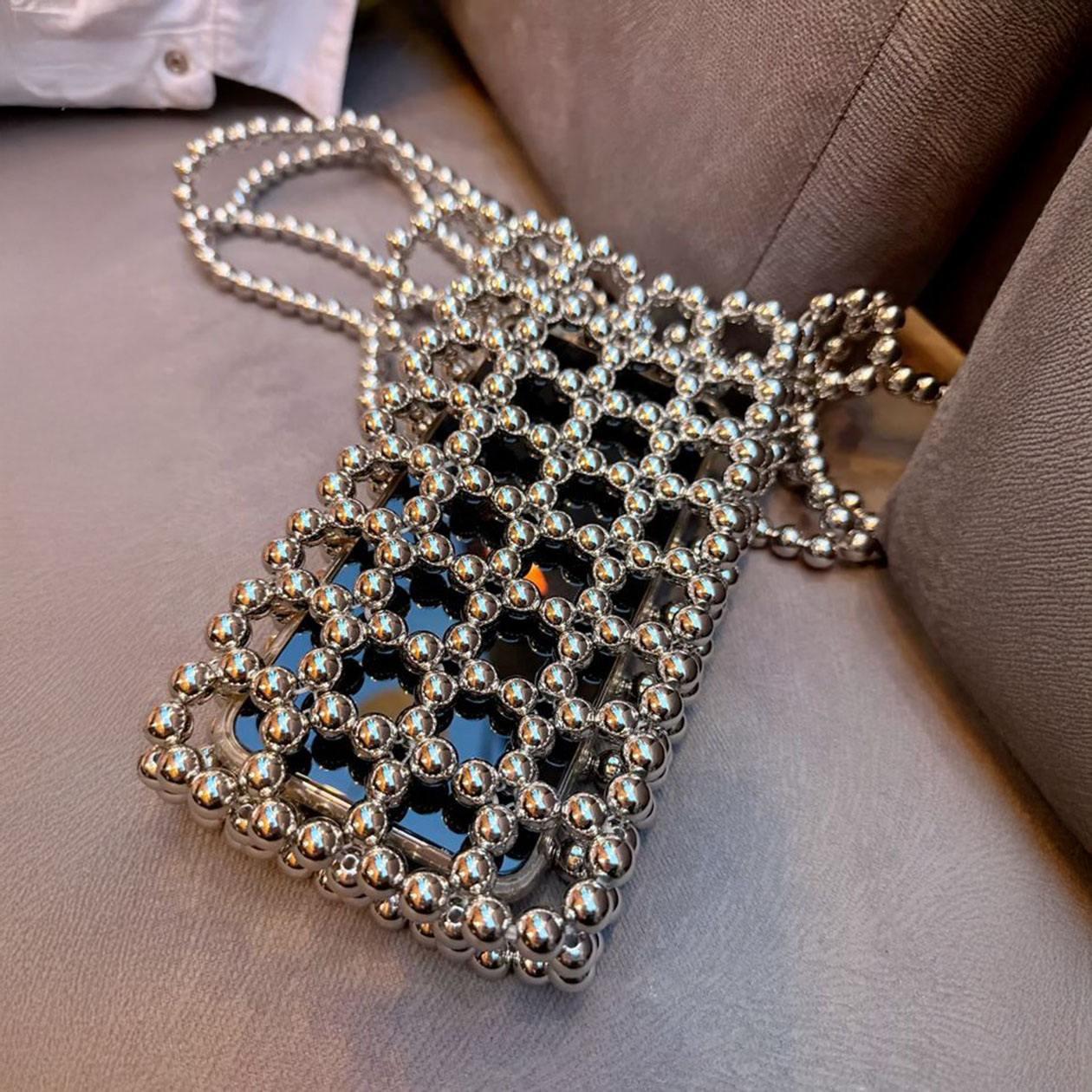 Сумочка из блестящих бусин. Сплетите полотно, которое в 2—2,5 раза шире телефона. Согните заготовку пополам и провяжите край леской, добавляя сверху и снизу по бусинке. Так закроете готовое полотно. © pinterest.com