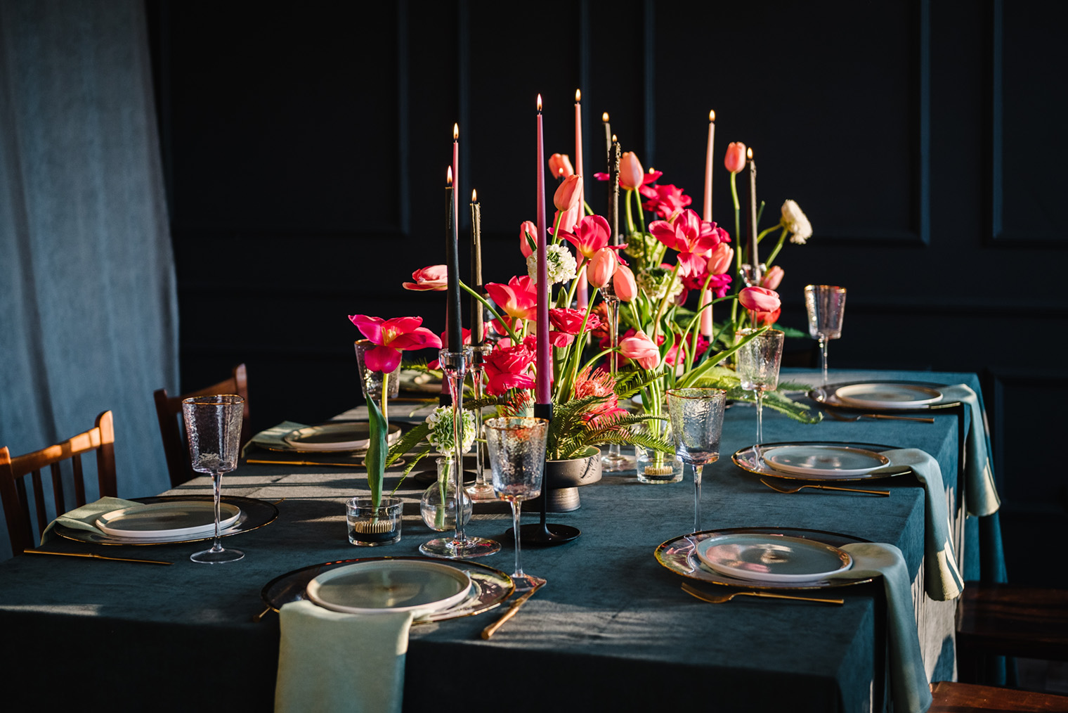 Этот стол украшен темными подсвечниками и яркими цветами. Фотография: Sergii Sobolevskyi / Shutterstock / FOTODOM