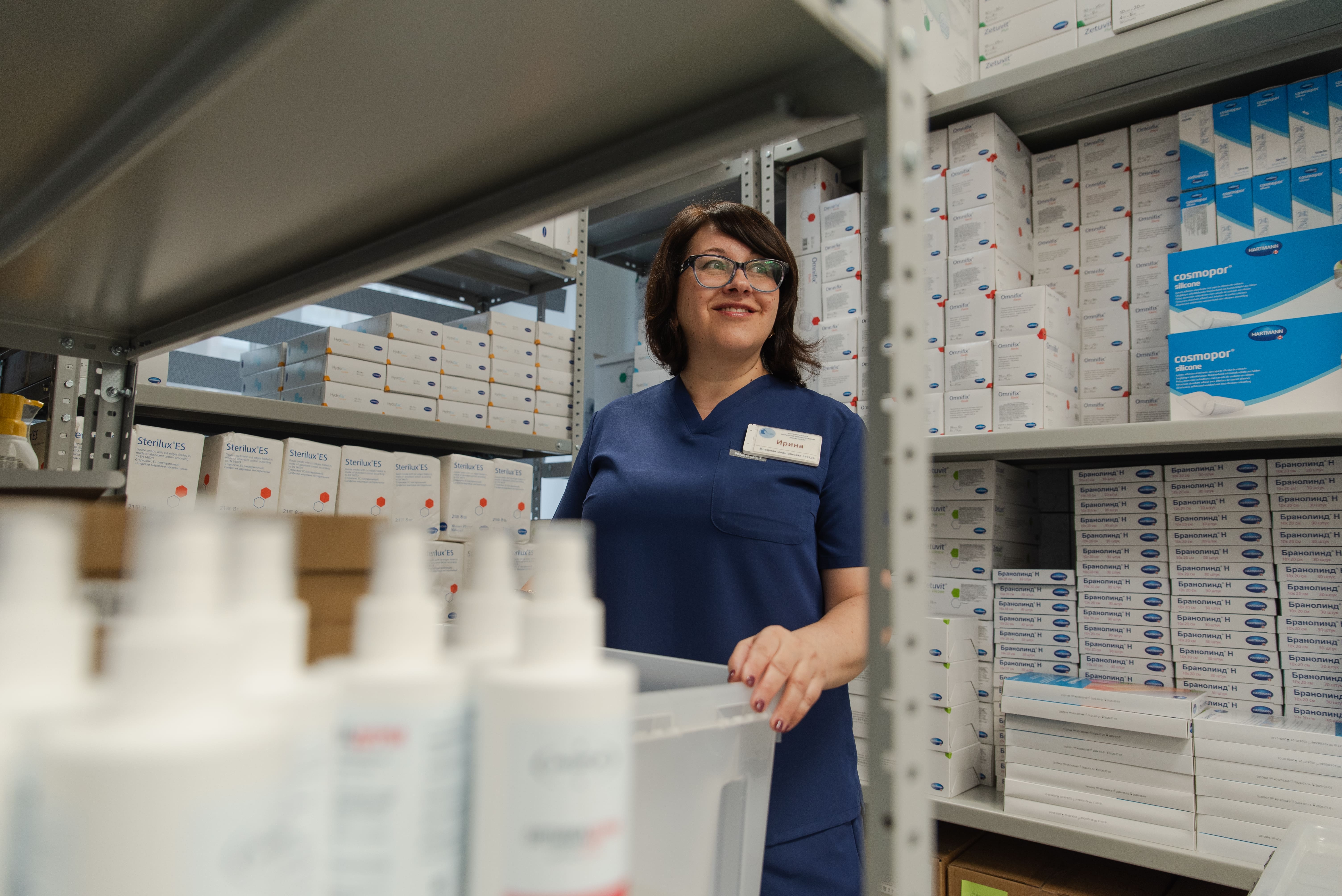 Младшая медицинская сестра Ирина на складе хосписа. Она несколько часов в день проводит с пациентами, выполняя гигиенические процедуры и предоставляя возможность семье заняться своими делами