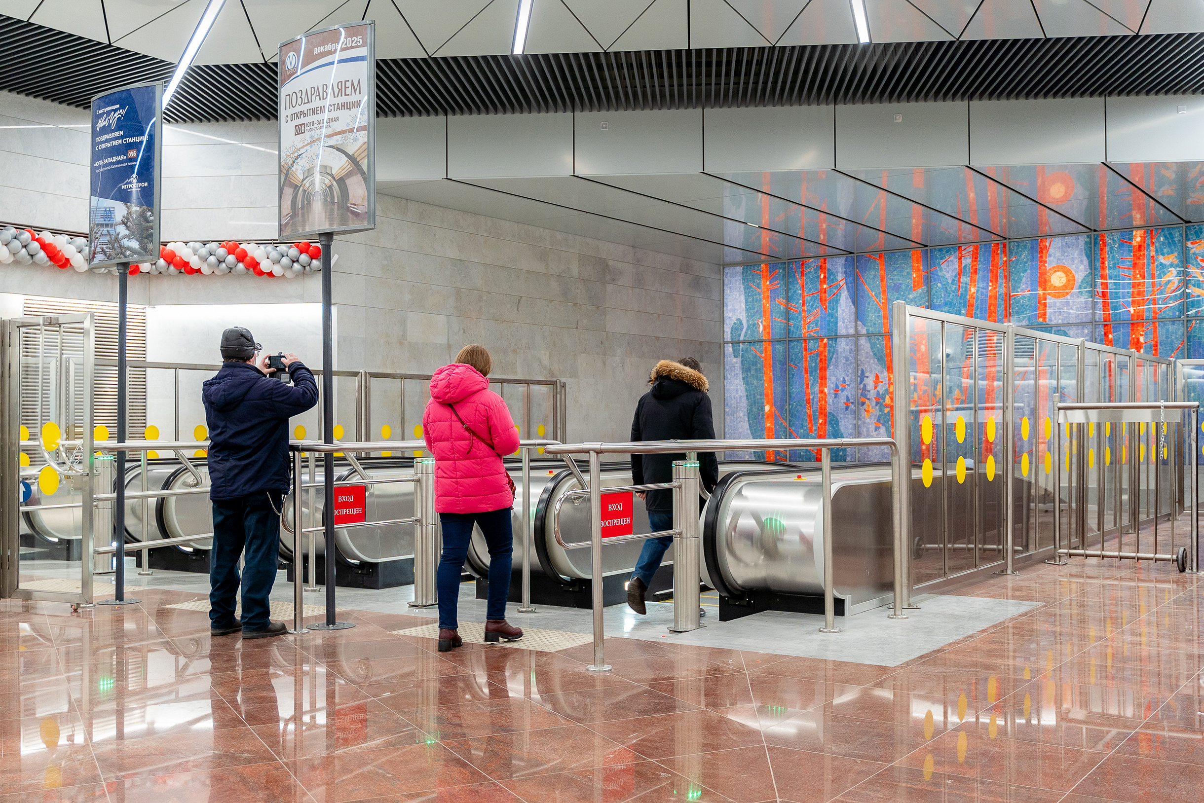 Люди останавливаются перед эскалаторами, чтобы сфотографировать композицию