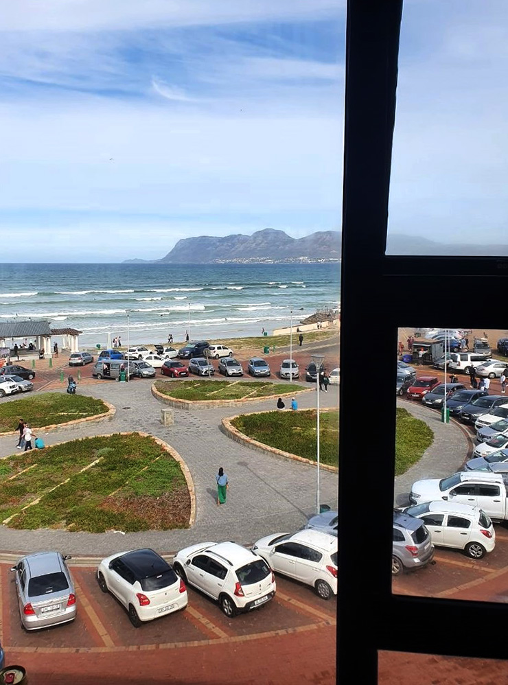 Вид из окна на площадь, где паркуются все, кто приезжает на пляж