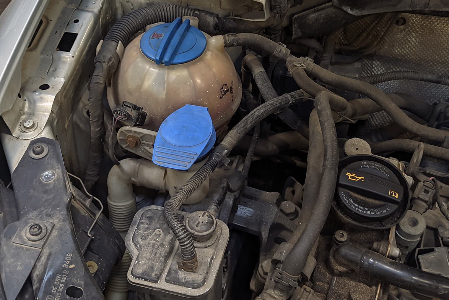 В Volkswagen Golf 6 крышку горловины бачка омывателя сделали яркого синего цвета, находится она рядом с расширительным бачком