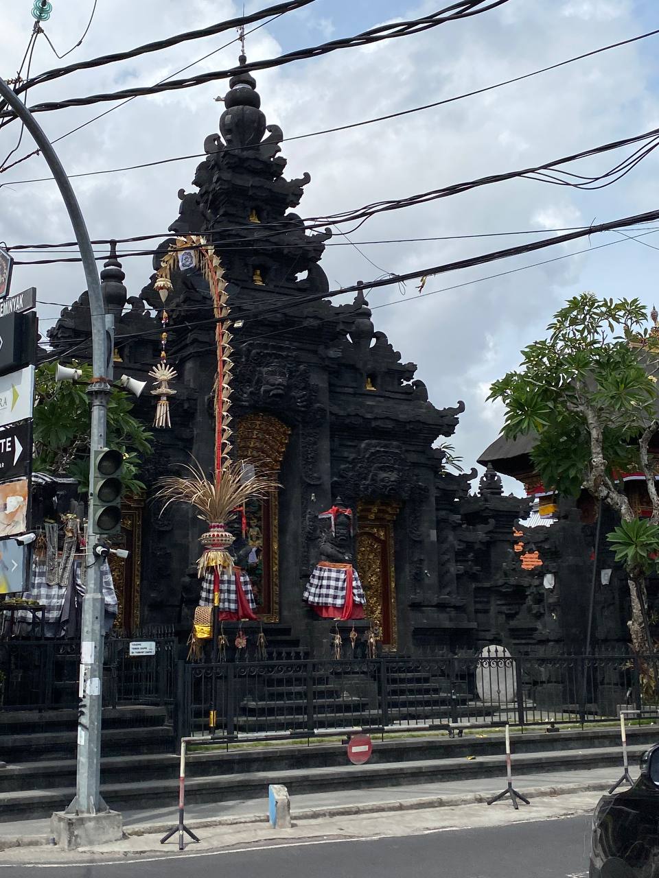 Балийский храм, а перед ним пенджор (penjor), установленный к празднику и символизирующий местную гору Агунг