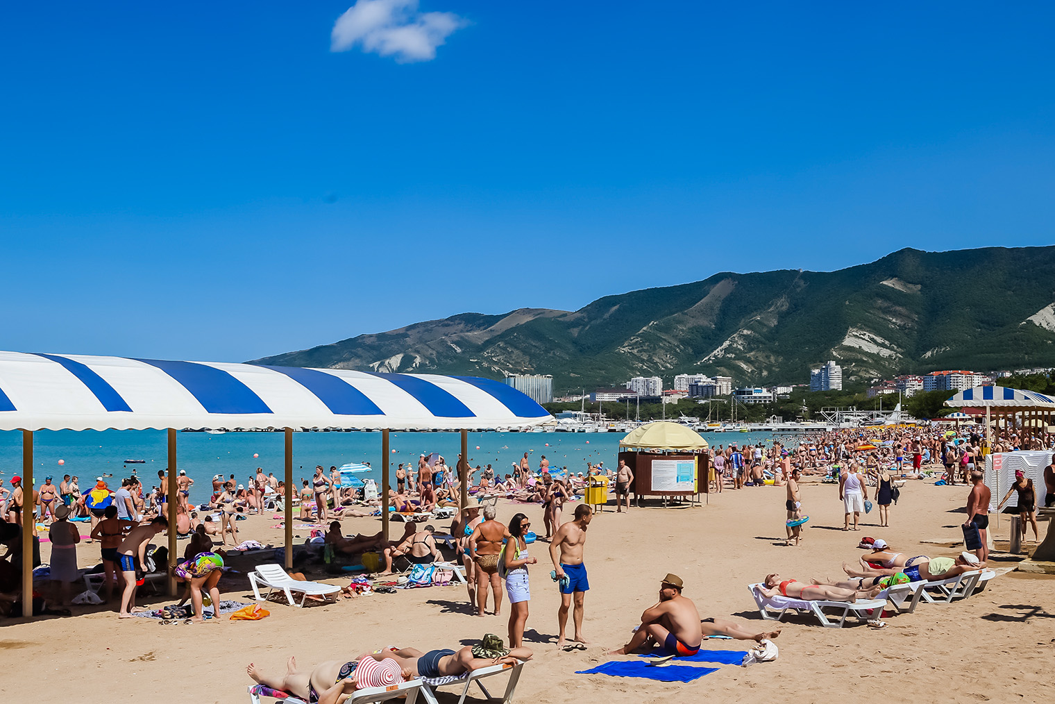 В августе трудно найти свободное место на пляже у самого моря. Фотография: nikolpetr / Shutterstock