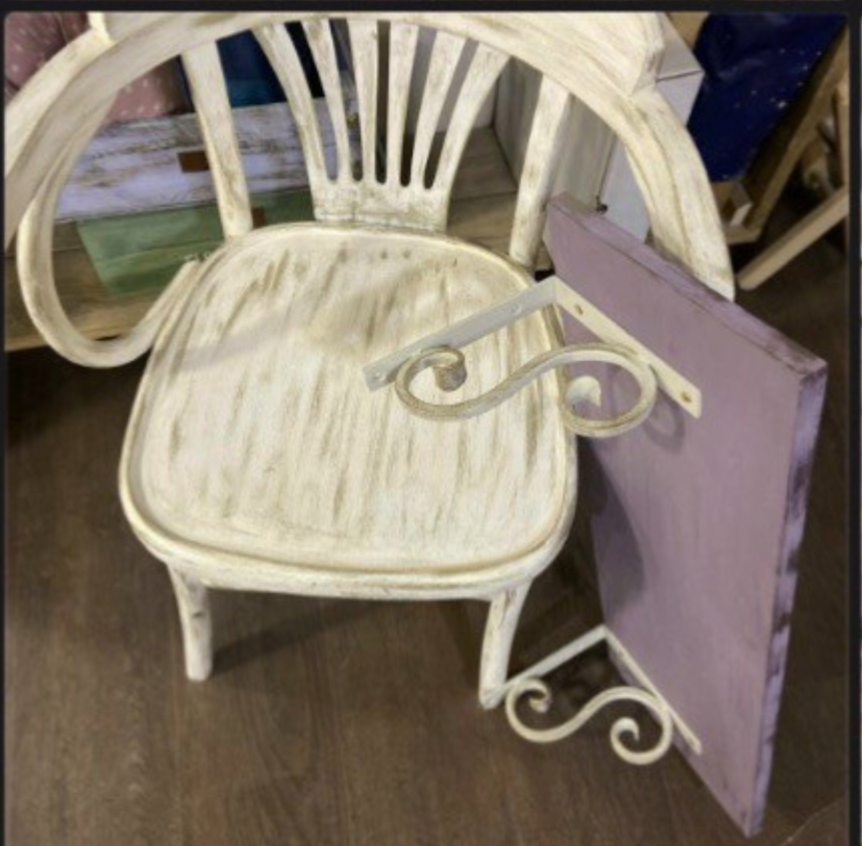 Общий план: белый стул с новой спинкой рядом с лавандовой полкой на кованых кронштейнах