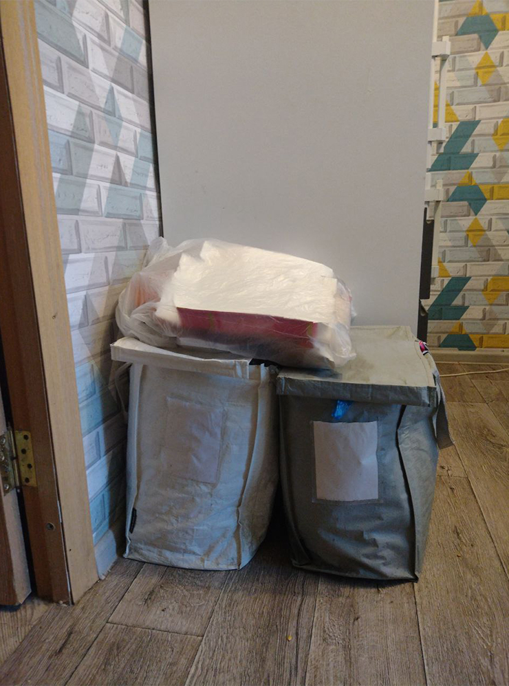 Два контейнера для первого этапа сортировки и пакет для бумаги, расположенные на кухне