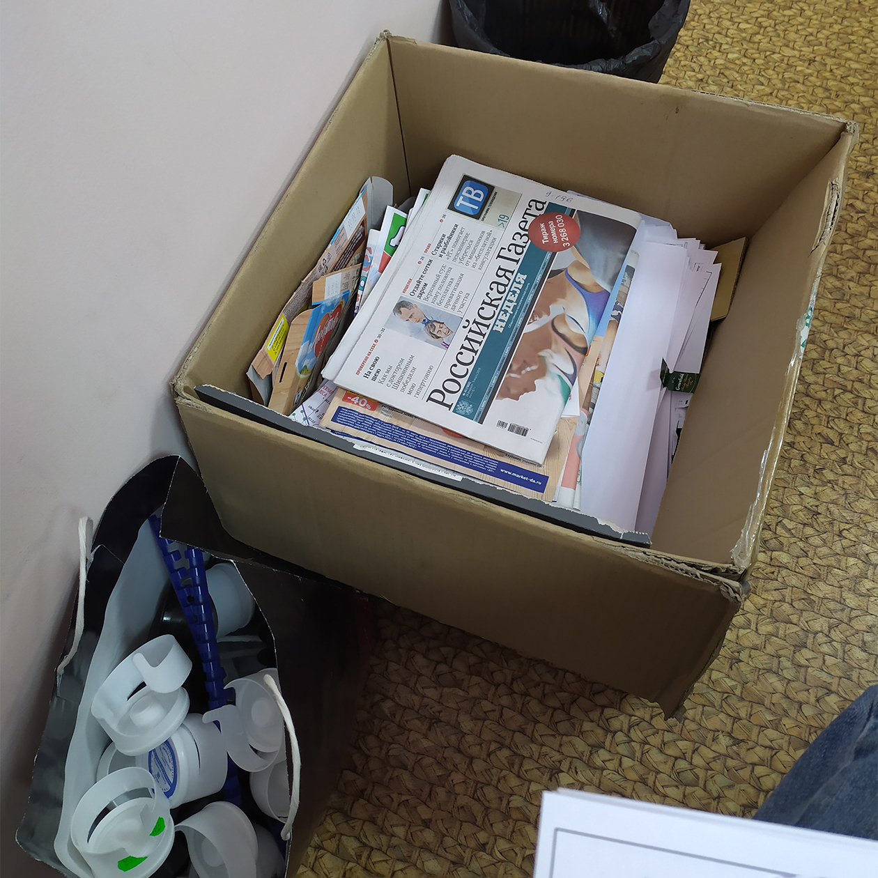 Коробка для газет, архивов, черновиков под моим рабочим местом. Рядом с ней — пакет с пластиковыми крышечками от 19⁠-⁠литровых бутылей, которые отношу в контейнер у дома