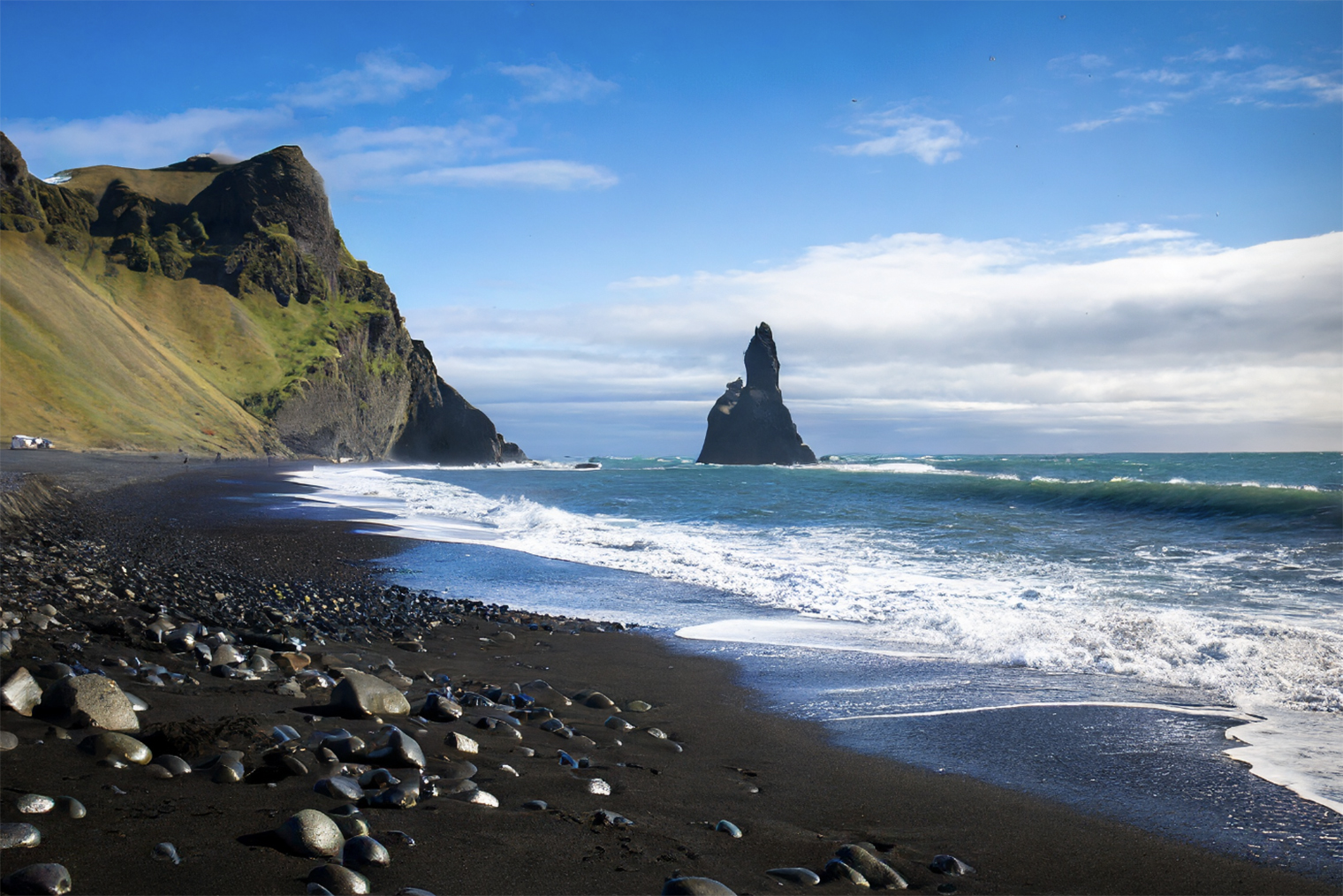 Реалистичное фото исландского пляжа с черным песком, чистой водой и камнями, стиль композиции «пейзажная фотосъемка»