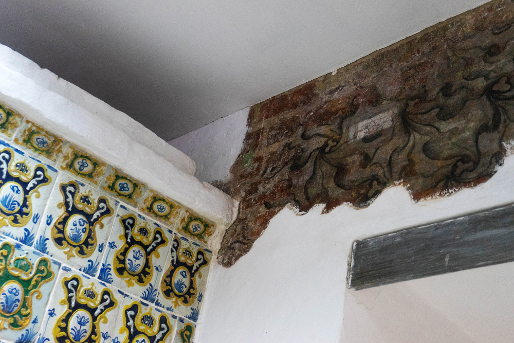 Кое⁠-⁠где на потолке, например около изразцовой печи, специально смыли штукатурку, чтобы обнажить исторические росписи