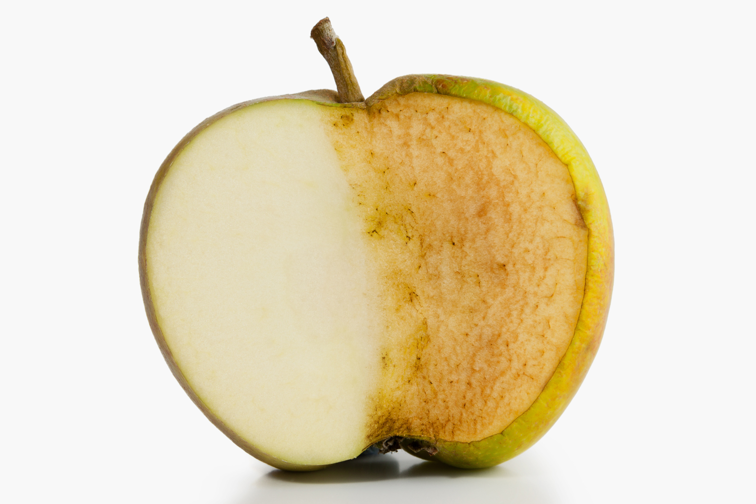 Левая половинка свежесрезанного яблока белая. Но уже примерно через пять минут разрезанное яблоко темнеет — это видно на его правой половине. Источник: dpullman / iStock