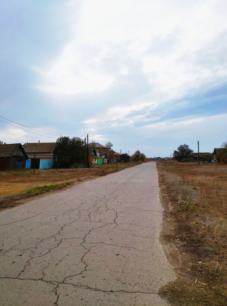 Пустынная дорога, переходящая в главную деревенскую улицу