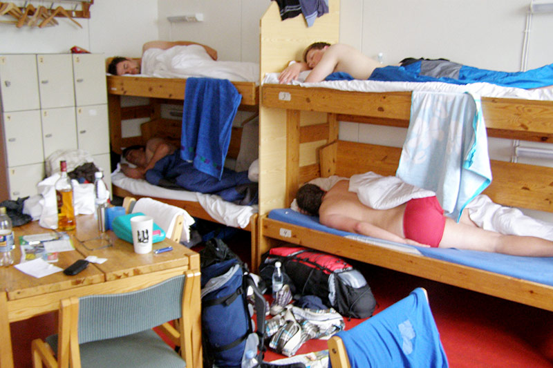 Плохой хостел: кровати без ограничителей и шторок, вещи разбросаны, на столе алкоголь (фото из блога Эшли Бринкман)
