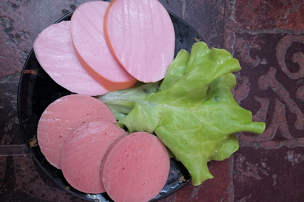 Снизу растительная колбаса — она пористая, в отличие от мясной
