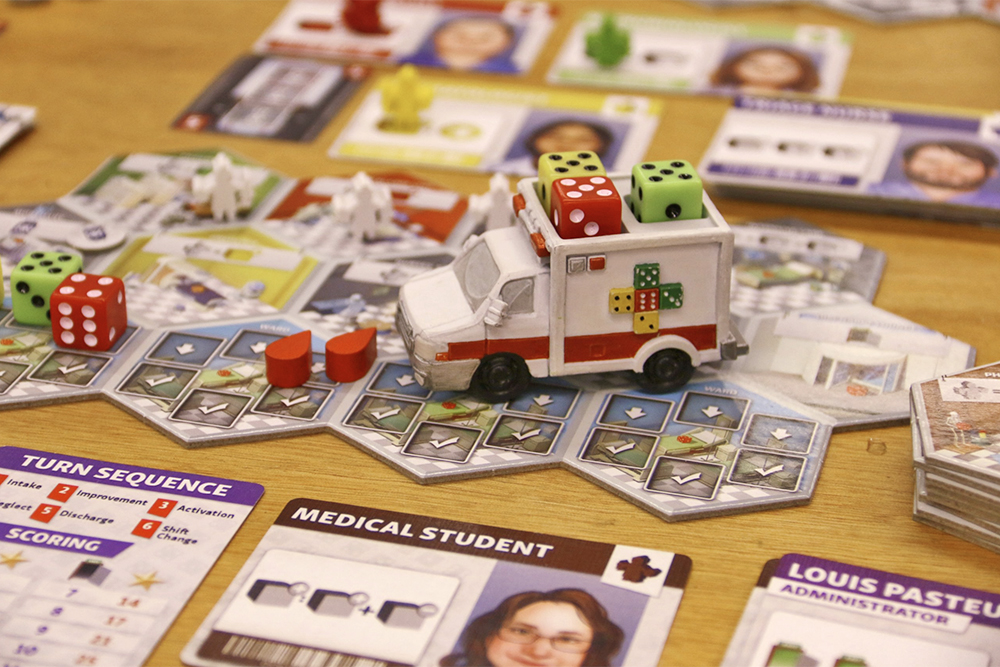 В игре Dice Hospital кубики — это пациенты, а количество точек обозначает их здоровье. К больнице их подвозит карета скорой помощи. Источник: Despellentrein