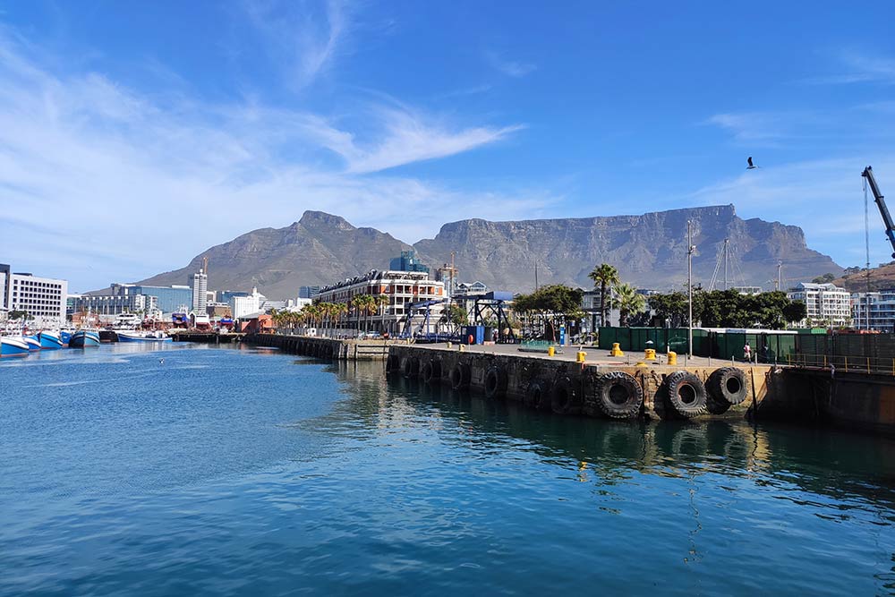 Порт Кейптауна и Столовая гора на заднем плане, ее высота — 1087 метров. Это главный символ Кейптауна, веками ее силуэт на горизонте говорил мореплавателям, что впереди долгожданная бухта, где можно пополнить запасы еды и пресной воды