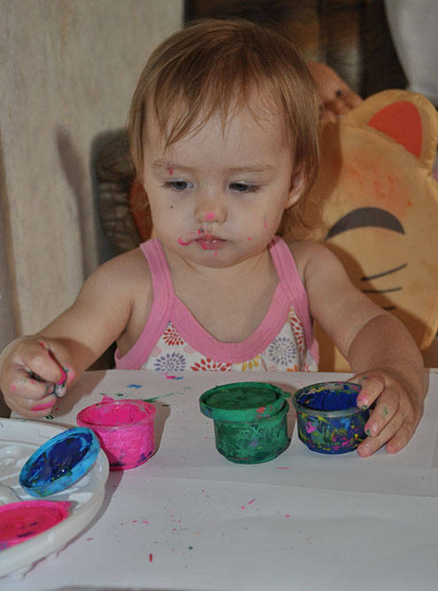 Годовалая дочь рисует пальчиковыми красками. Они сделаны из нетоксичных материалов — можно не бояться отравления, даже если ребенок начнет тянуть пальцы в рот