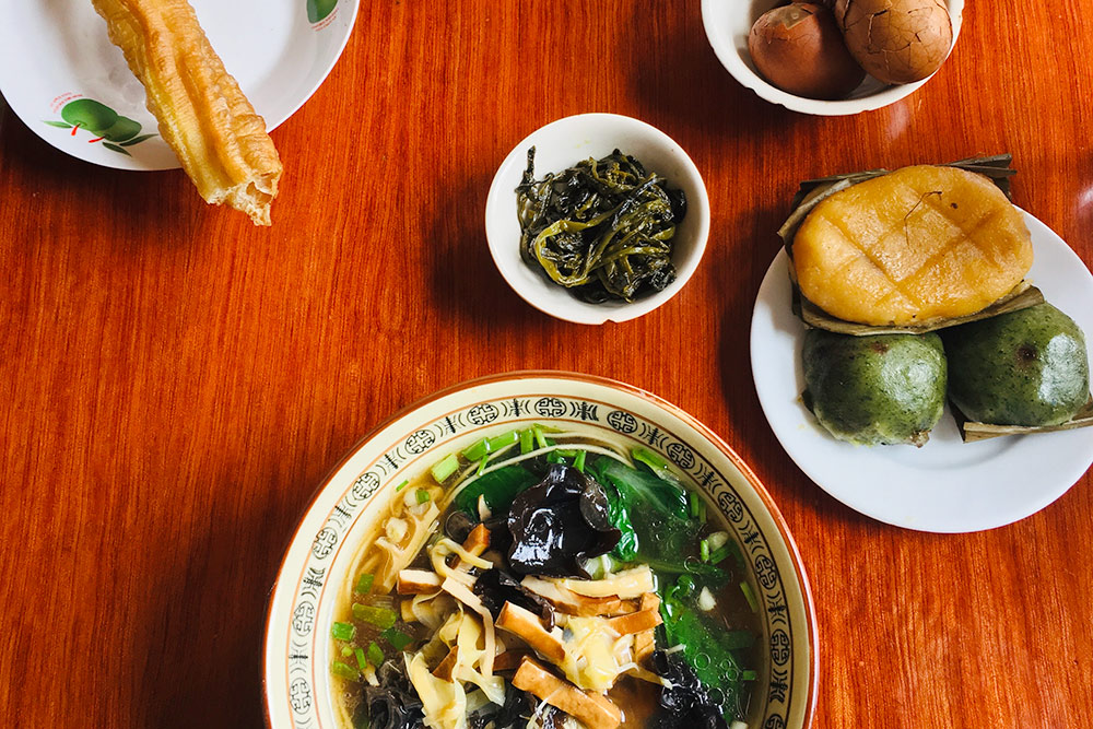 Это типичный китайский завтрак: суп с лапшой, овощами и тофу, жареный хлеб, пельмени, яйца, рисовый десерт и булочка. Еще обычно китайцы пьют по утрам теплое молоко