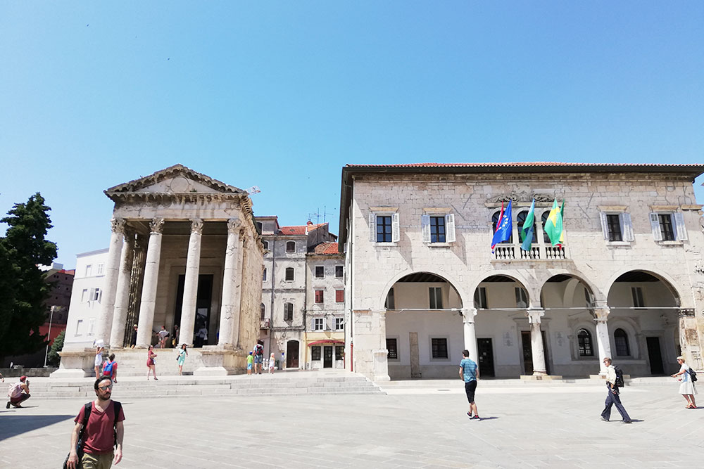 Главная площадь старого города. Слева — храм императора Августа, а справа — ратуша