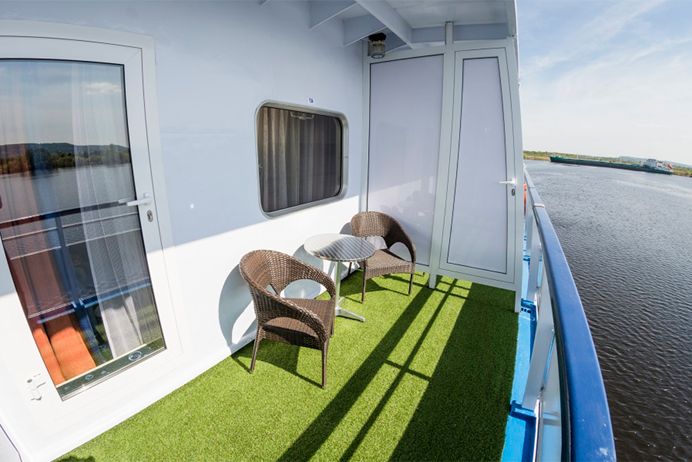 Главное отличие номера — персональный балкон со стульями для отдыха. Источник: s⁠-⁠cruises.com}(https://s-cruises.com/ships/lebedinoye_ozero/)
