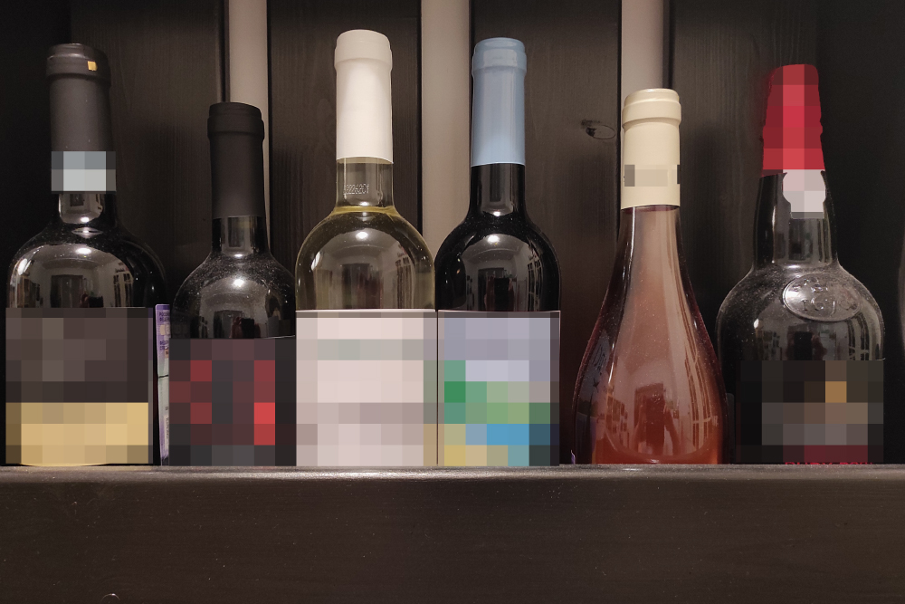 Основная полка с вином на кухне, крепкое стоит на другой, а часть напитков — в холодильнике