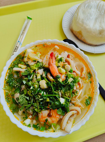 Суп со сложным названием на вкуснейшем бульоне, с лапшой, кальмаром, креветками, какими⁠-⁠то ростками и зеленью