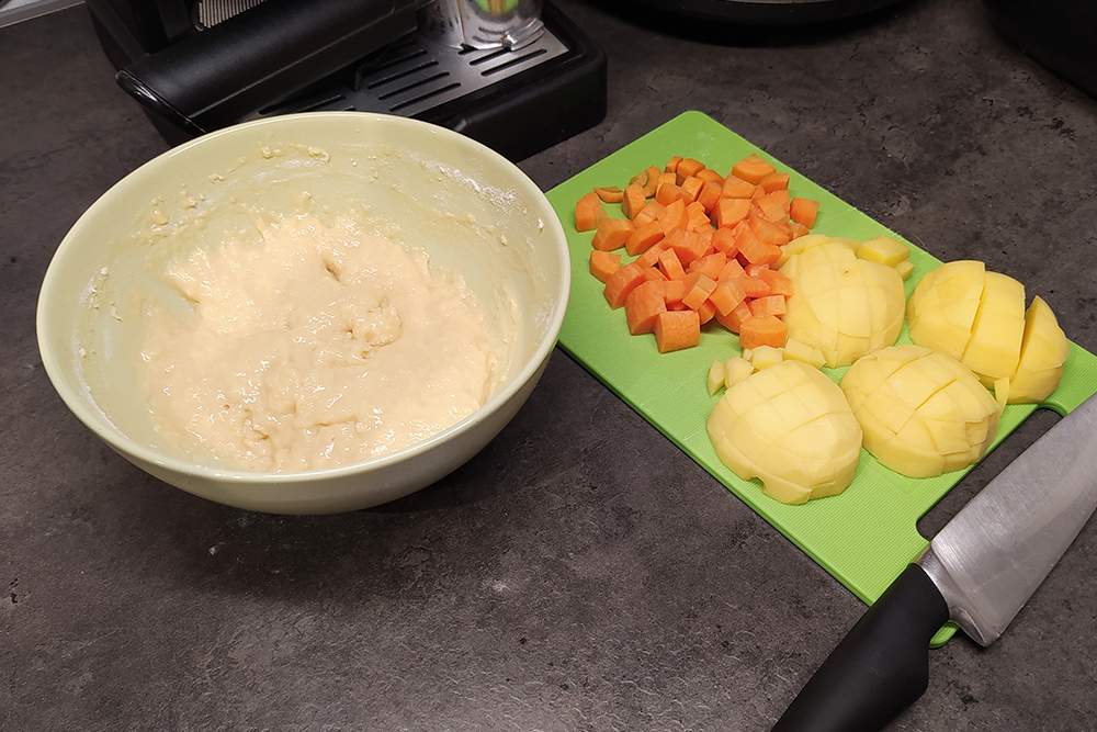 Пока закипает вода, чищу картошку и морковку, замешиваю тесто на клецки. После закипания дважды снимаю пену и оставляю слабо кипеть на 40 минут