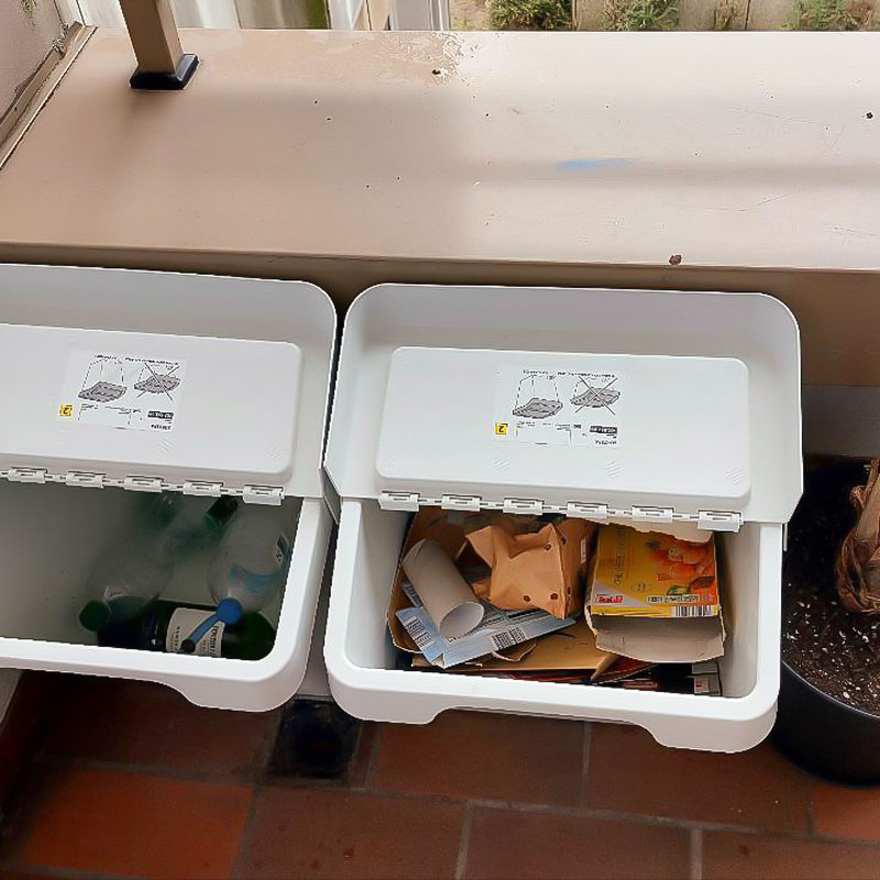 На балконе два ведра для сортировки мусора: справа для бумаги, слева для пластиковых и стеклянных бутылок