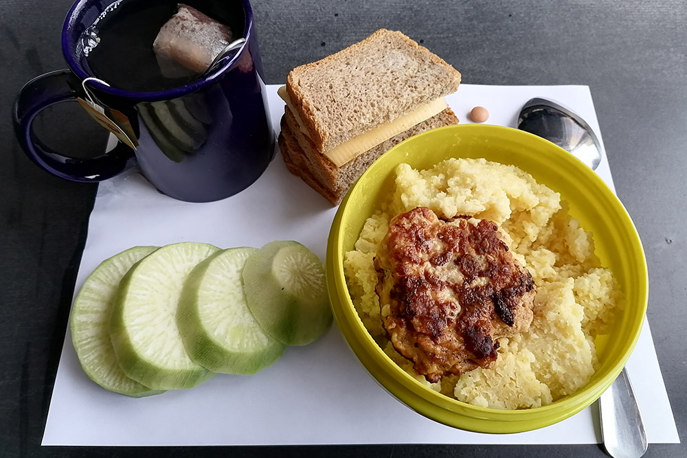 На обед пшенная каша с котлетой, остатки редьки и чай с бутербродами: один такой же, как утром, — с маслом, сыром и огурцом, второй со сгущенным молоком