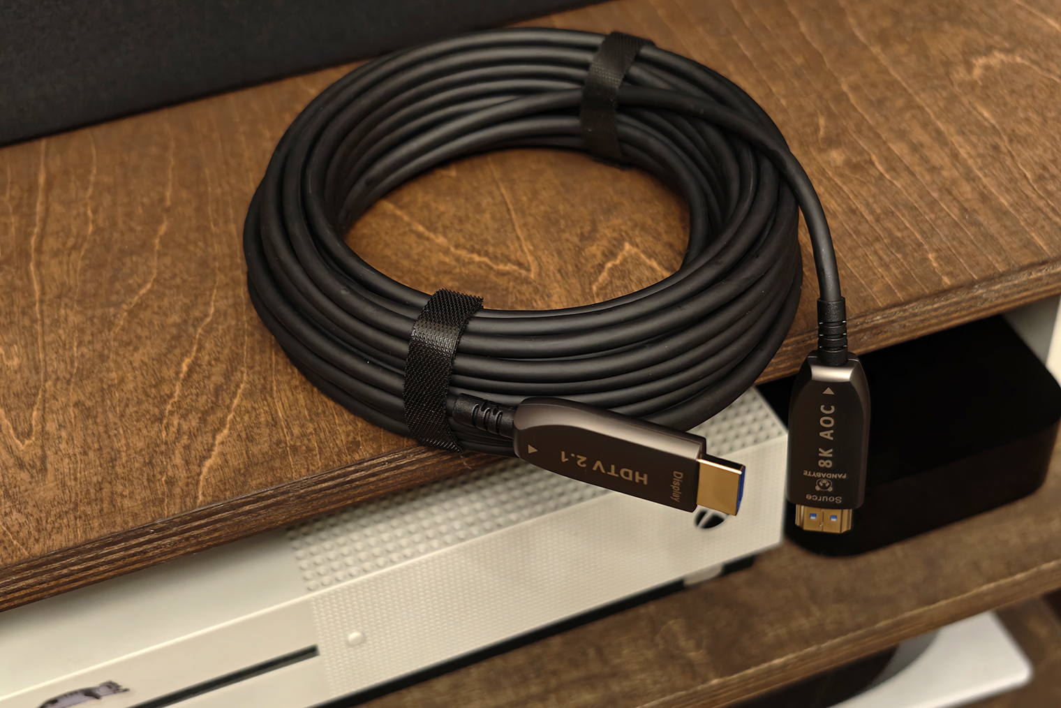 Оптический HDMI-кабель длиной 15 метров. Будьте очень осторожны: внутри он очень хрупкий, и если согнуть его под углом 90°, жилы из оптоволокна могут переломиться. А еще у него фиксированная направленность, втыкать его в проектор и в источник нужно так, как подписано на коннекторах