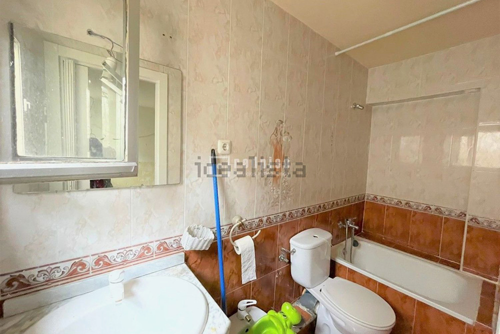 Санузел довольно тесный, но есть окно и небольшая ванна. Ванна — нетипична для Испании, обычно в квартирах устанавливают душ. Источник: idealista.com