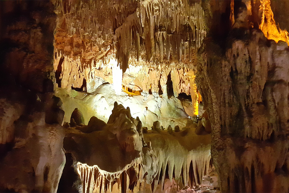 Благодаря подсветке сталактиты и сталагмиты в пещере напоминают инопланетный пейзаж