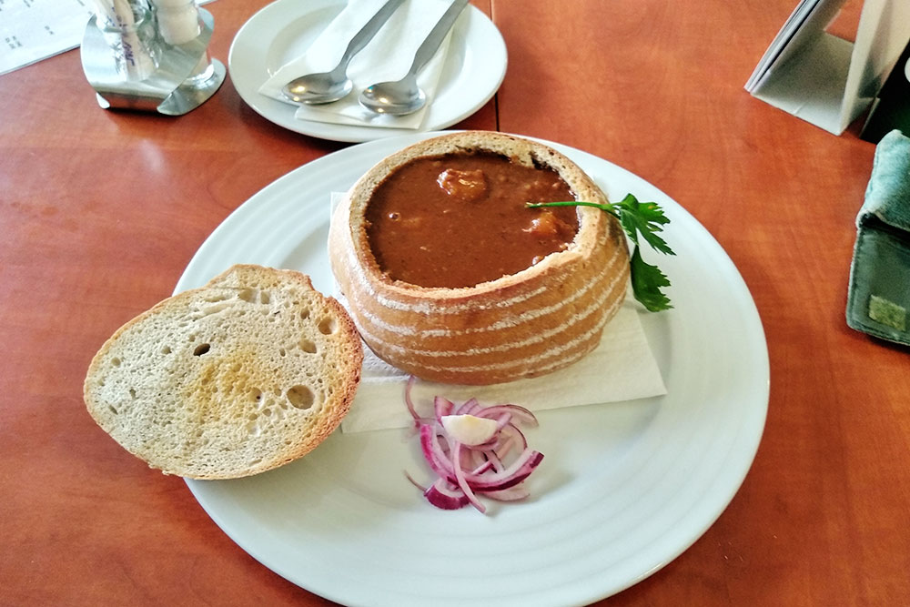 Полевка — чешский мясной суп. Иногда его подают прямо в хлебе. Суп съедают вместе с «тарелкой». Эта порция стоила 129 Kč (361 ₽)