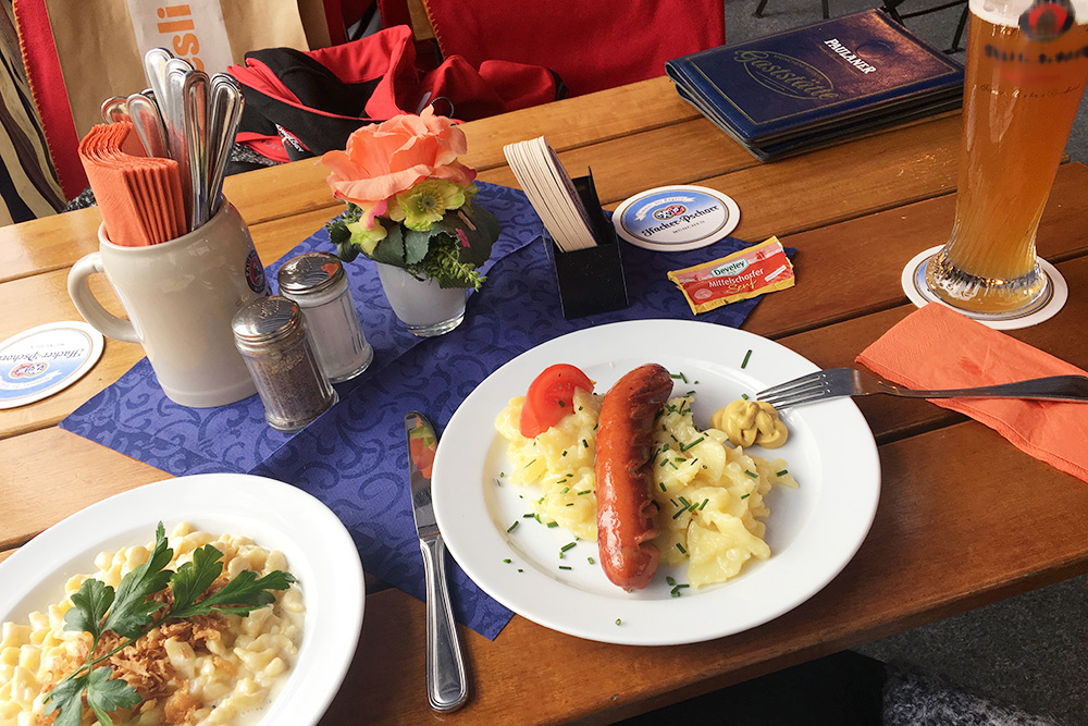 Слева традиционное баварское блюдо кэзешпетцле — домашняя лапша с сыром и сушеным луком. Зимой очень согревает. Стоит в среднем 8 € (560 рублей). Сосиски часто подают с холодным картофельным салатом, стоит такая порция 10 € (700 рублей)