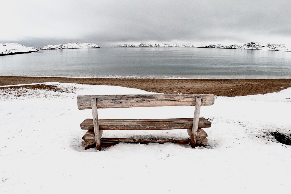 В зимней Териберке — особенная атмосфера: на песчаном пляже лежит снег, а над горами витает туман