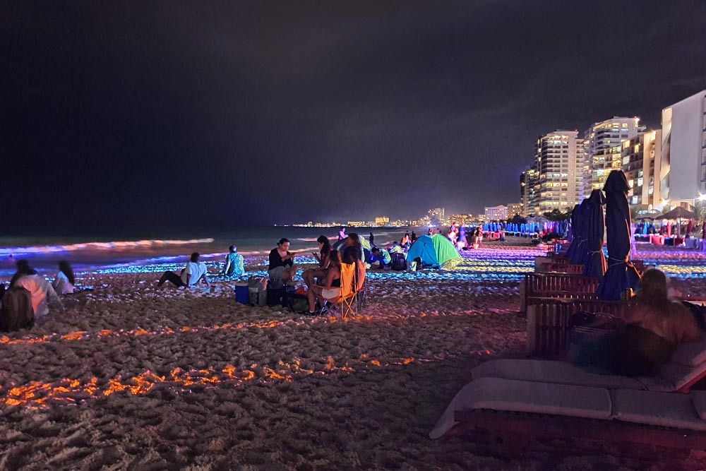 Пляж Канкуна в новогоднюю ночь заполнен туристами. В Hard Rock Cafe играет музыка, все веселятся и отмечают, организовав пикник, некоторые даже с палатками. Здесь спокойнее, чем на площади возле клубов