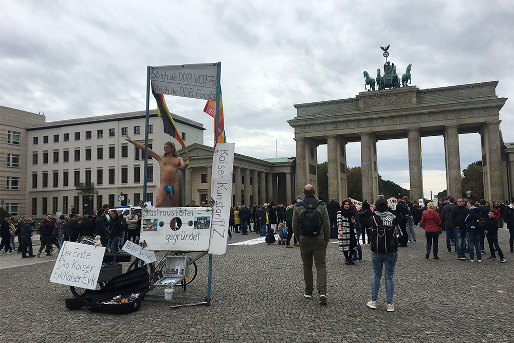 Ситуация у Бранденбургских ворот: туристы и протестующий голый мужчина. Спустя год я снова приехала в Берлин, а парень стоял на том же месте