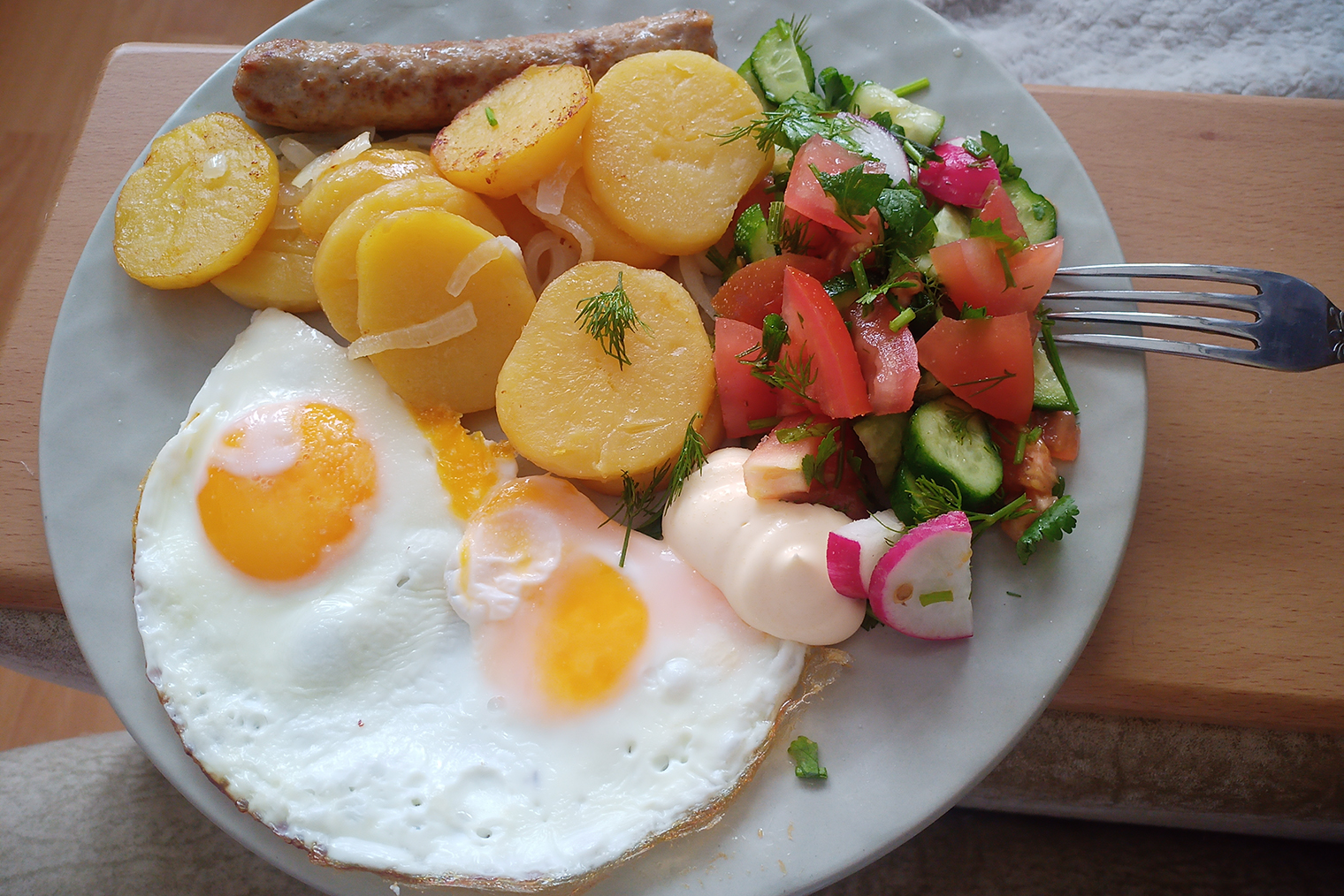 Стандартный завтрак в выходной — яичница с жареной картошкой, сосиской и овощным салатом