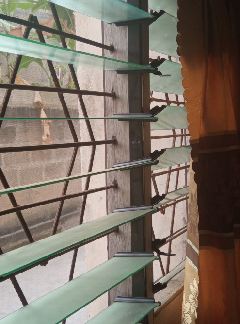 Окно устроено сложно: москитная сетка от насекомых, решетка от воров, стеклянные жалюзи от ветра и пыли, шторы от солнца