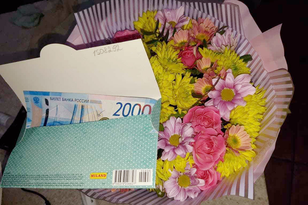 Так может выглядеть подарок, если решили дарить деньги: 2000 ₽ в конверте и букет цветов. Преподаватель сам купит себе то, что хочет. Фото: Анастасия Корнилова