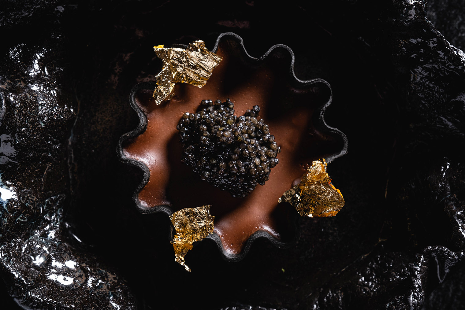 Тарт с перуанским шоколадом приносят на черном волнистом блюде, повторяющем изгибы тарталетки. Источник: maya.lucky-group.rest