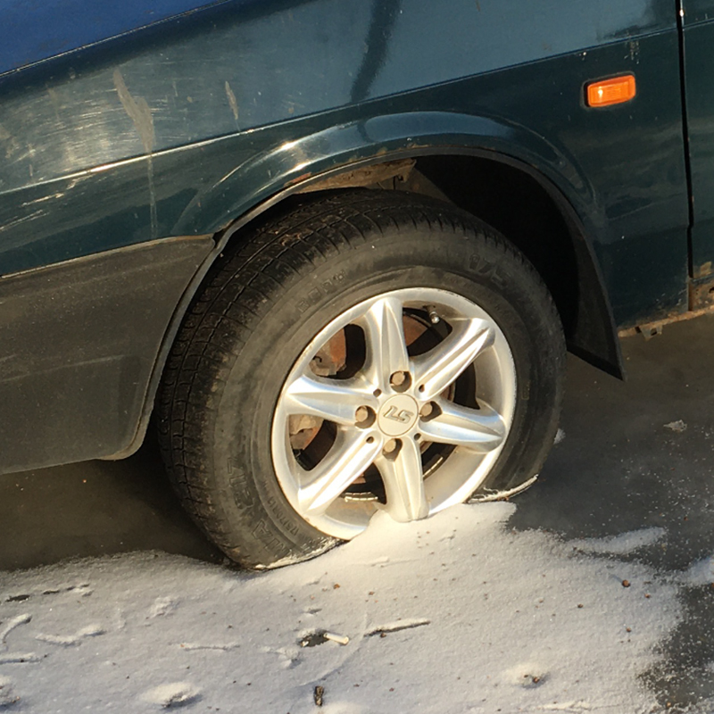 Владелец этого автомобиля выбрал для стоянки низину. Из⁠-⁠за образовавшихся луж колесо со временем вмерзло в лед