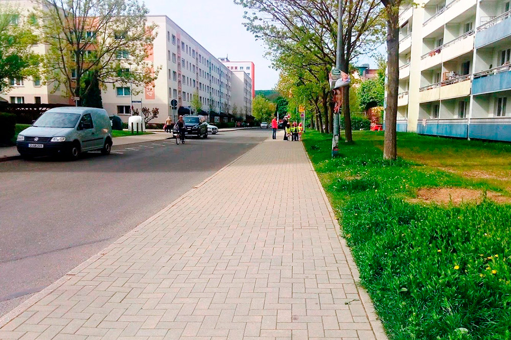 Слева дом, в котором я живу, — это типичная пятиэтажка времен ГДР. Но так как все дома покрашены, улицы убраны, а территория облагорожена, в районе нет гнетущей атмосферы, подобной той, что царит в похожих спальных районах с пятиэтажками в России