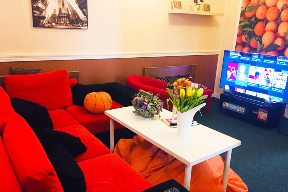 В «Оранж-хостеле» общая зона небольшая: пара диванов, столик, торшер и телевизор. Источник: booking.com