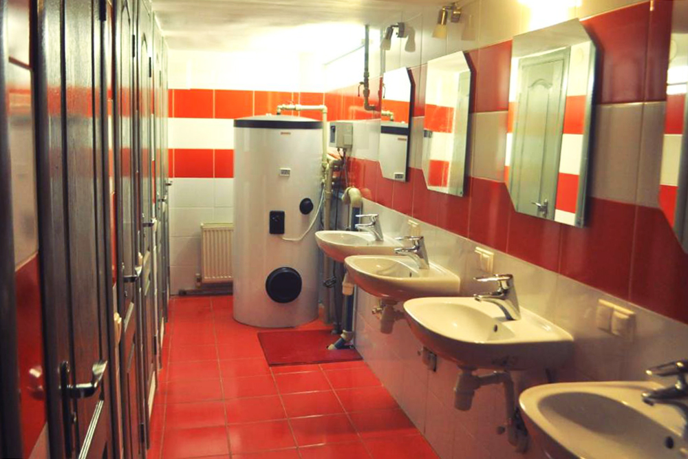 3D Hostel в Одессе. Несомненный плюс — отдельные душевые, туалеты и умывальники. На заднем плане — бойлер. Минус — снизу кабины никак не отгорожены, так что помещение легко затапливается. Источник: booking.com