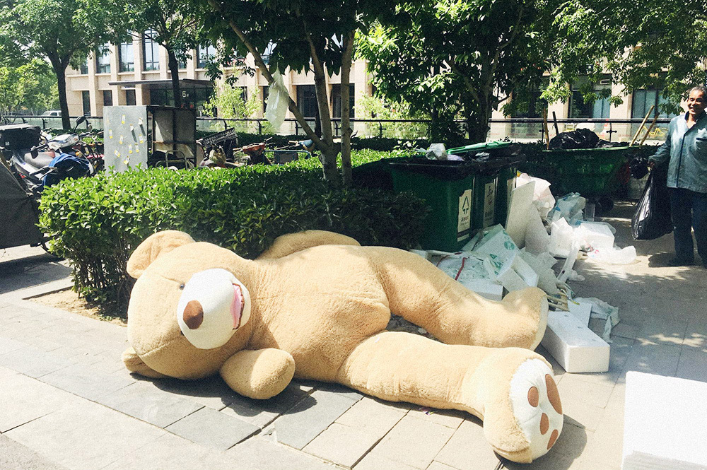 Китайцы любят мягкие игрушки. Этого гигантского медведя выбросили на помойку, но когда-то же он кому-то понравился