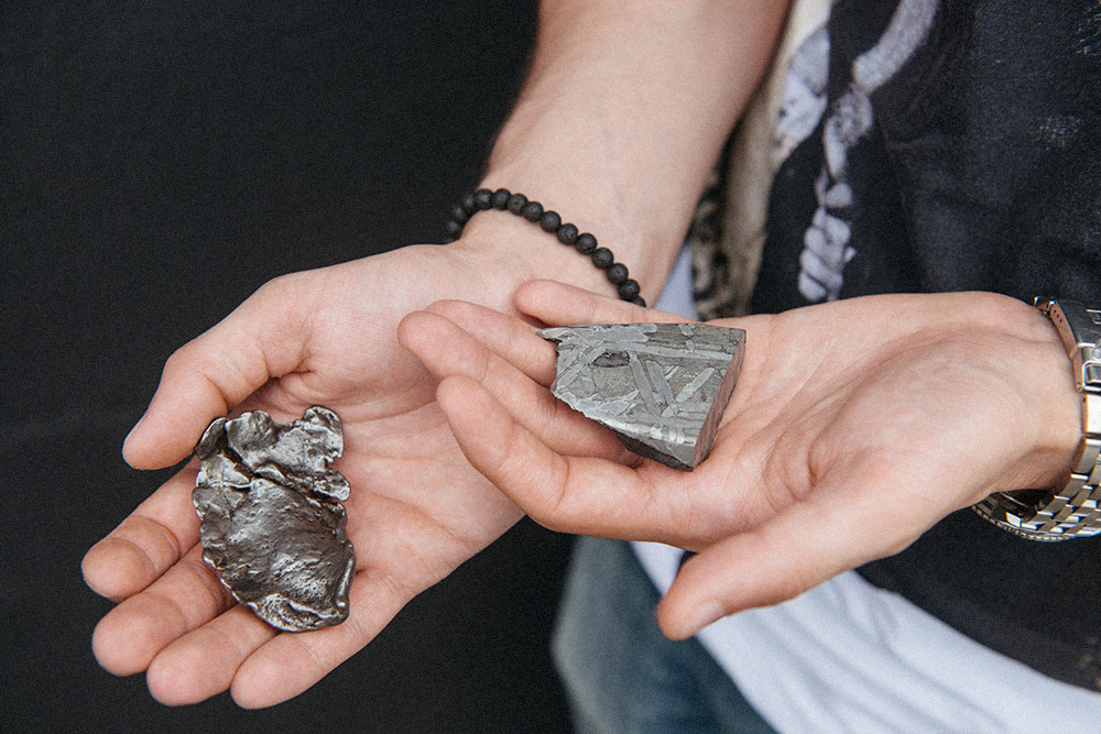 В левой руке — железокаменный метеорит Сеймчан, в правой — железный Сихотэ-Алинь