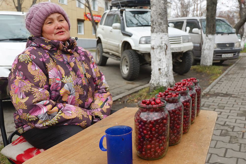 Корсаков. Бабушка продает клюкву, собранную «на болоте среди медведей», по 500 рублей за литр