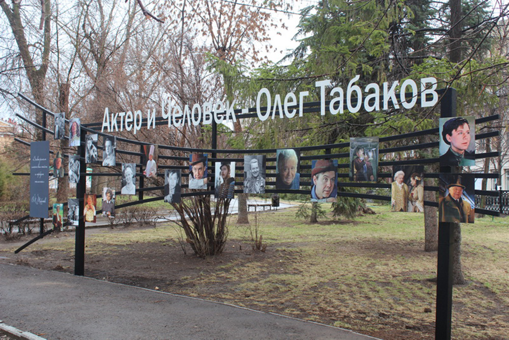 В сквере имени Олега Табакова стоит стенд с его фотографиями