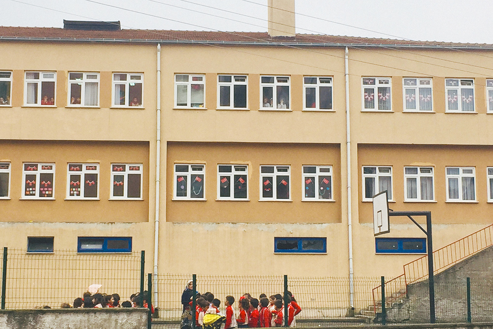 В детях воспитывают патриотизм: окна украшены флагами Турции, каждый ребенок должен знать национальный гимн. На фото — начальная школа, в ней учатся с 1 по 3 класс, потом переходят в другое здание к другим учителям
