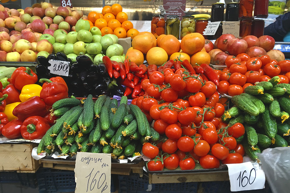 Летом огурцы и помидоры продаются на рынке по 30—40 рублей за кг. На фото цены марта 2019 года